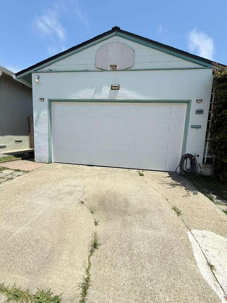 Traditional short-panel white steel garage door on a canyon-edge ranch home in Castro Valley